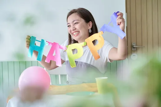 カラフルなHAPPYのガーランドを持つ女性